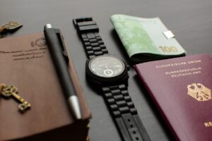 German passport, mobile phone, and travel accessories on a table